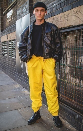 Come indossare e abbinare pantaloni sportivi gialli: Coniuga un giubbotto bomber in pelle nero con pantaloni sportivi gialli per un look semplice, da indossare ogni giorno. Scegli uno stile classico per le calzature e scegli un paio di stivali casual in pelle neri.