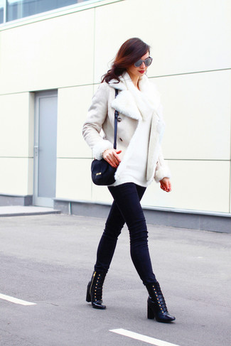 Look alla moda per donna: Giubbotto in shearling bianco, Maglione con scollo a cappuccio bianco, Jeans aderenti neri, Stivaletti con lacci in pelle neri