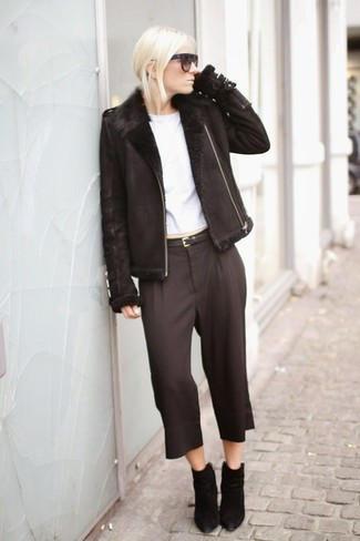 Look alla moda per donna: Giubbotto in shearling nero, T-shirt girocollo bianca, Pinocchietti neri, Stivaletti in pelle scamosciata neri