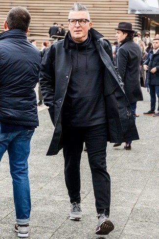 Come indossare e abbinare un impermeabile nero per un uomo di 50 anni: Per un outfit quotidiano pieno di carattere e personalità, potresti combinare un impermeabile nero con chino neri. Per un look più rilassato, mettiti un paio di scarpe sportive grigie.