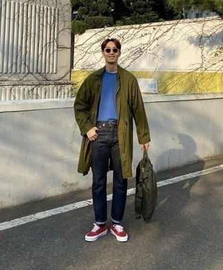 Look alla moda per uomo: Impermeabile verde oliva, T-shirt girocollo blu, Jeans blu scuro, Sneakers basse di tela rosse e bianche