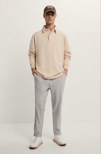 Moda uomo anni 20: Metti una maglia  a polo beige e chino di seersucker grigi per essere elegante ma non troppo formale. Scegli un paio di sneakers basse in pelle bianche per un tocco più rilassato.