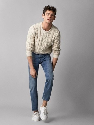 Quale jeans indossare con un maglione a trecce beige in primavera 2024 in modo casual: La versatilità di un maglione a trecce beige e jeans li rende capi in cui vale la pena investire. Questo outfit si abbina perfettamente a un paio di sneakers basse di tela bianche. È fantastica scelta per un outfit primaverile!