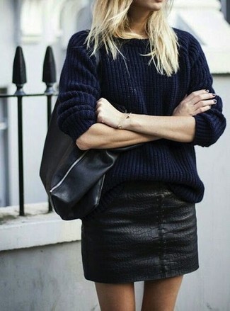Look alla moda per donna: Maglione a trecce blu scuro, Minigonna in pelle nera, Borsa shopping in pelle nera