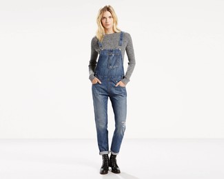 Look alla moda per donna: Maglione a trecce grigio, Salopette di jeans blu, Stivali piatti stringati in pelle neri