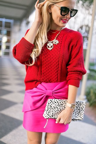 Look alla moda per donna: Maglione a trecce rosso, Minigonna fucsia, Pochette in pelle leopardata bianca, Occhiali da sole neri