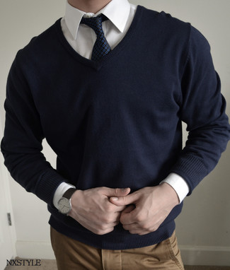 Come indossare e abbinare un maglione con scollo a v blu scuro in modo smart-casual: Indossa un maglione con scollo a v blu scuro e chino marrone chiaro per un outfit comodo ma studiato con cura.