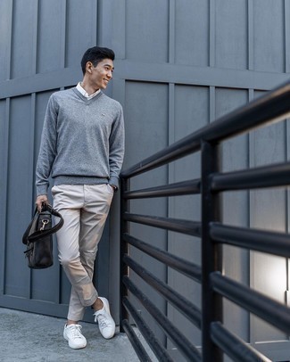 Come indossare e abbinare un maglione con scollo a v grigio per un uomo di 30 anni: Questa combinazione di un maglione con scollo a v grigio e chino grigi è perfetta per il tempo libero. Sneakers basse di tela bianche renderanno il tuo look davvero alla moda.