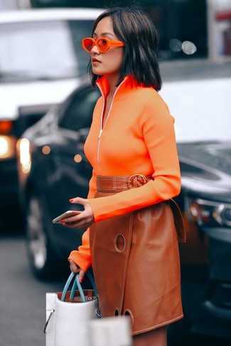 Come indossare e abbinare una gonna per una donna di 30 anni: Indossa un maglione con zip arancione e una gonna per un look trendy e alla mano.