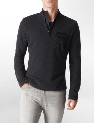 Come indossare e abbinare un maglione con zip nero: Metti un maglione con zip nero e jeans grigi per un look spensierato e alla moda.