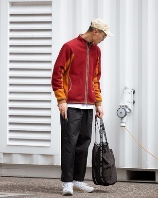 Moda uomo anni 20 in primavera 2024: Metti un maglione con zip di pile rosso e chino neri per un look spensierato e alla moda. Se non vuoi essere troppo formale, opta per un paio di scarpe sportive bianche. Questo è di sicuro l'outfit da copiare in questi mesi primaverili.