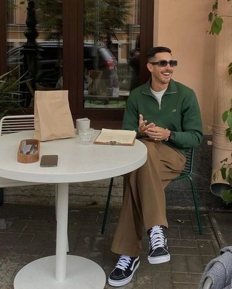 Look alla moda per uomo: Maglione con zip verde scuro, T-shirt girocollo bianca, Chino marroni, Sneakers alte di tela nere e bianche