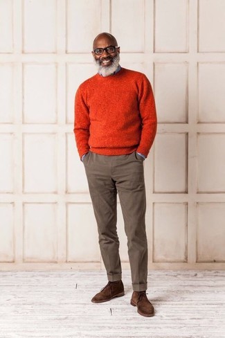 Look alla moda per uomo: Maglione girocollo arancione, Camicia di jeans azzurra, Chino marroni, Chukka in pelle scamosciata marroni