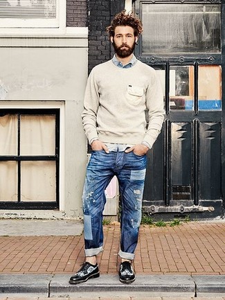Look alla moda per uomo: Maglione girocollo beige, Camicia di jeans azzurra, Jeans strappati blu, Scarpe brogue in pelle nere e bianche