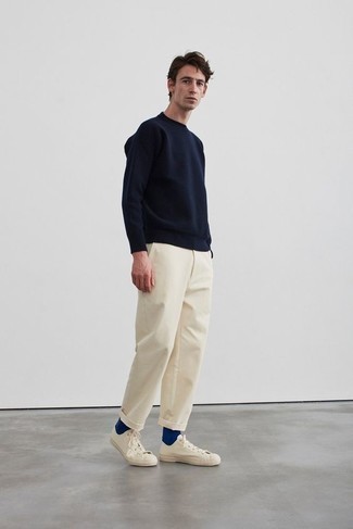 Look alla moda per uomo: Maglione girocollo blu scuro, Chino beige, Sneakers basse di tela beige, Calzini blu