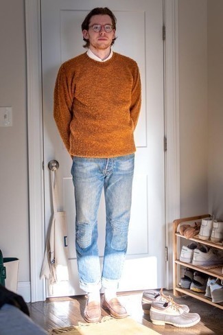 Moda uomo anni 30: Vestiti con un maglione girocollo terracotta e jeans patchwork azzurri per un look trendy e alla mano.