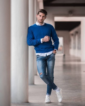 Look alla moda per uomo: Maglione girocollo blu, Camicia a maniche lunghe bianca, Jeans aderenti strappati blu, Sneakers basse in pelle bianche