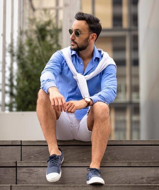 Look alla moda per uomo: Maglione girocollo bianco, Camicia a maniche lunghe blu, Sneakers basse di tela blu scuro e bianche, Occhiali da sole verde scuro