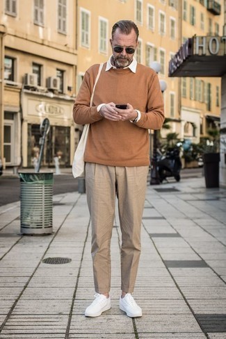 Quale maglione girocollo indossare con chino beige in modo smart-casual: Prova a combinare un maglione girocollo con chino beige per un look spensierato e alla moda. Per un look più rilassato, calza un paio di sneakers basse in pelle bianche.