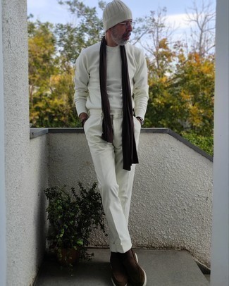 Come indossare e abbinare scarpe per un uomo di 50 anni: Indossa un maglione girocollo bianco con chino di velluto a coste bianchi per un look raffinato per il tempo libero. Opta per un paio di mocassini eleganti in pelle scamosciata marrone scuro per un tocco virile.