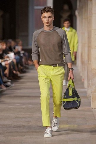 Look alla moda per uomo: Maglione girocollo marrone, Chino gialli, Sneakers basse di tela grigie, Borsa per lo sport di tela blu scuro