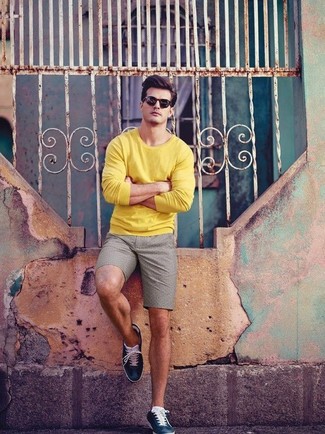 Quale pantaloncini indossare con un maglione girocollo giallo per un uomo di 30 anni: Mostra il tuo stile in un maglione girocollo giallo con pantaloncini per un look spensierato e alla moda. Perfeziona questo look con un paio di sneakers basse in pelle blu scuro.