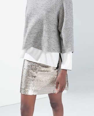 Come indossare e abbinare una minigonna con paillettes argento: Prova a combinare un maglione girocollo grigio con una minigonna con paillettes argento per un look raffinato.