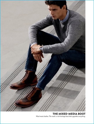 Look alla moda per uomo: Maglione girocollo grigio, Camicia a maniche lunghe azzurra, Jeans blu scuro, Stivaletti brogue in pelle marroni