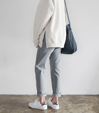 Look alla moda per donna: Maglione oversize bianco, Jeans boyfriend grigi, Sneakers basse in pelle bianche e nere, Borsa a tracolla di tela grigia