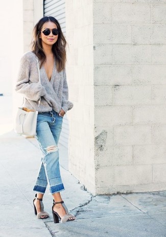 Quale jeans indossare con un maglione oversize grigio per una donna di 30 anni: Indossa un maglione oversize grigio con jeans per un look comfy-casual. Perfeziona questo look con un paio di sandali con tacco di pelliccia grigi.