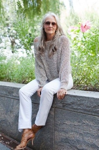 Come indossare e abbinare sandali in pelle per una donna di 60 anni quando fa caldo: Combina un maglione oversize lavorato a maglia grigio con jeans bianchi per un look facile da indossare. Per un look più rilassato, opta per un paio di sandali in pelle.