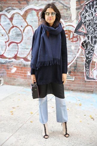 Look alla moda per donna: Maglione oversize nero, Sottoveste nera, Jeans a campana azzurri, Stivaletti in pelle bianchi e neri
