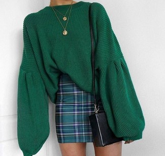 Look alla moda per donna: Maglione oversize lavorato a maglia verde, Minigonna scozzese verde scuro, Borsa a tracolla in pelle nera, Collana con ciondolo dorata