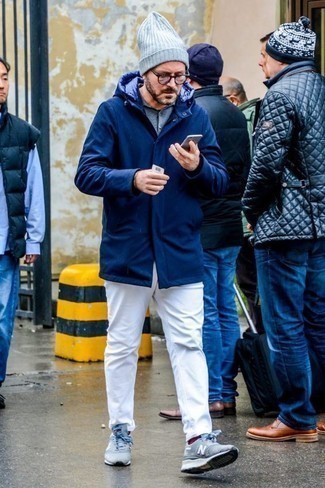 Look alla moda per uomo: Parka blu scuro, Camicia a maniche lunghe in chambray azzurra, Jeans bianchi, Scarpe sportive azzurre