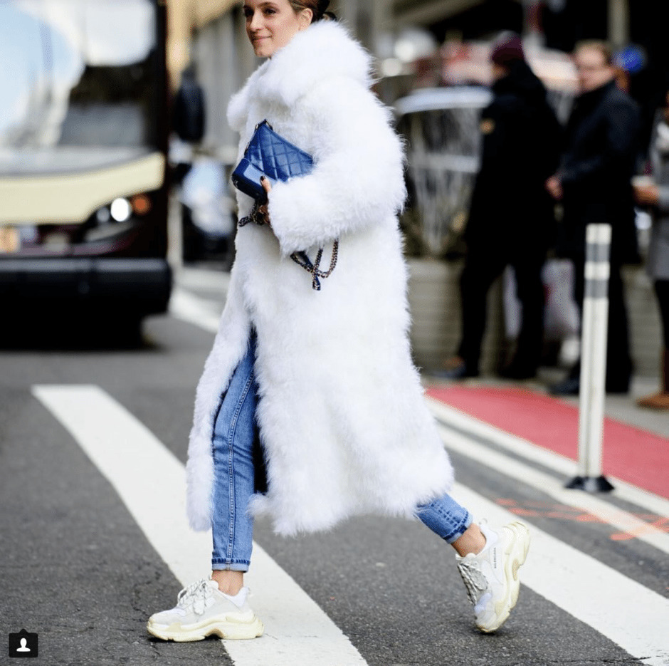 Look alla moda per donna: Pelliccia bianca, Jeans aderenti blu, Scarpe  sportive bianche, Borsa a tracolla in pelle blu