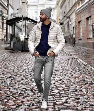 Come indossare e abbinare jeans grigi con sneakers basse di tela bianche: Prova ad abbinare un piumino bianco con jeans grigi per creare un look smart casual. Scegli un paio di sneakers basse di tela bianche come calzature per avere un aspetto più rilassato.