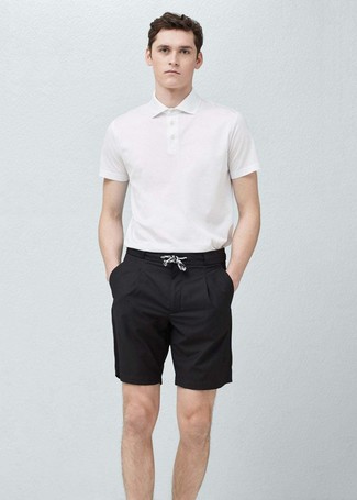 Come indossare e abbinare un polo bianco e blu scuro per un uomo di 20 anni: Combina un polo bianco e blu scuro con pantaloncini neri per un outfit comodo ma studiato con cura.