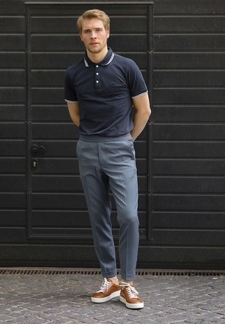 Moda uomo anni 20 quando fa molto caldo in modo casual: Abbina un polo blu scuro con chino blu per vestirti casual. Sneakers basse in pelle marroni sono una splendida scelta per completare il look.