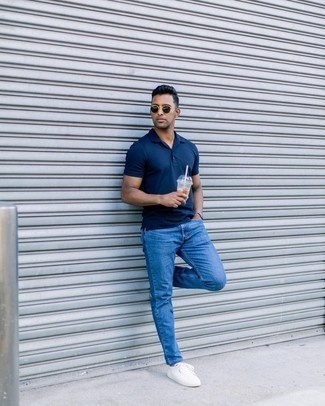 Come indossare e abbinare jeans blu per un uomo di 30 anni: Per un outfit quotidiano pieno di carattere e personalità, potresti indossare un polo blu scuro e jeans blu. Completa questo look con un paio di sneakers basse di tela bianche.