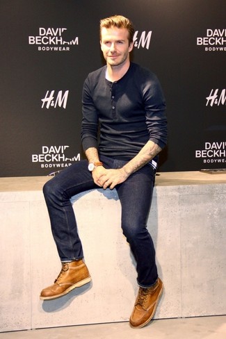 Look di David Beckham: Serafino manica lunga nero, Jeans blu scuro, Stivali casual in pelle marrone chiaro, Orologio in pelle marrone