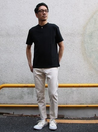 Look alla moda per uomo: Serafino nero, Jeans bianchi, Sneakers basse di tela bianche, Occhiali da sole trasparenti