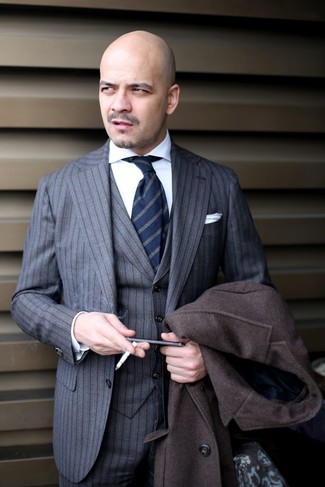 Come indossare e abbinare una cravatta a righe verticali blu scuro per un uomo di 40 anni quando fa freddo: Abbina un soprabito marrone scuro con una cravatta a righe verticali blu scuro per una silhouette classica e raffinata