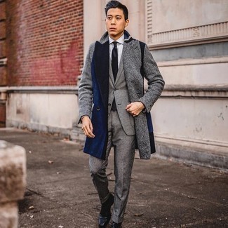 Come indossare e abbinare un abito a quadri grigio per un uomo di 20 anni in modo formale: Potresti indossare un abito a quadri grigio e un soprabito grigio per un look elegante e di classe. Scarpe oxford in pelle blu scuro sono una splendida scelta per completare il look.