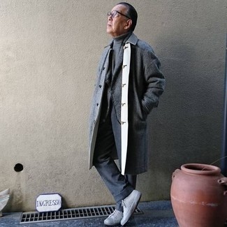 Come indossare e abbinare un soprabito grigio scuro per un uomo di 60 anni: Coniuga un soprabito grigio scuro con pantaloni eleganti grigio scuro per essere sofisticato e di classe. Indossa un paio di sneakers basse di tela grigie per un tocco più rilassato.