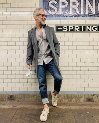 Quale soprabito indossare con sneakers basse bianche per un uomo di 50 anni in modo smart-casual: Prova ad abbinare un soprabito con jeans blu scuro per creare un look smart casual. Per distinguerti dagli altri, mettiti un paio di sneakers basse bianche.