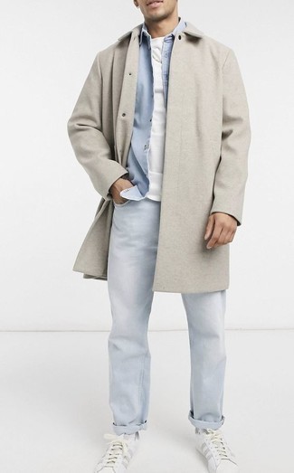 Trend da uomo 2024 quando fa freddo: Indossa un soprabito grigio e jeans azzurri se cerchi uno stile ordinato e alla moda. Se non vuoi essere troppo formale, indossa un paio di sneakers basse in pelle bianche.