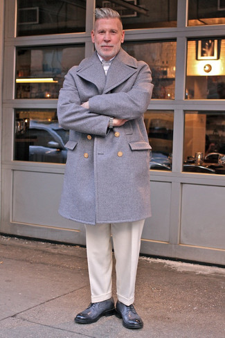 Come indossare e abbinare pantaloni con scarpe per un uomo di 50 anni quando fa gelo: Combina un soprabito grigio con pantaloni per un look elegante e alla moda. Opta per un paio di scarpe derby in pelle grigie per un tocco virile.