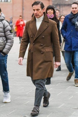Moda uomo anni 50 in primavera 2025: Indossa un soprabito marrone con pantaloni eleganti di lana grigio scuro come un vero gentiluomo. Se non vuoi essere troppo formale, calza un paio di scarpe monk in pelle marrone scuro. Ecco un look primaverile perfetto per il tuo.