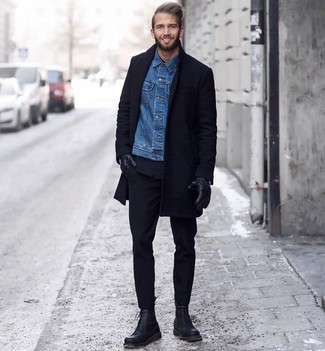 Look alla moda per uomo: Soprabito nero, Giacca di jeans blu, Chino neri, Stivali casual in pelle neri