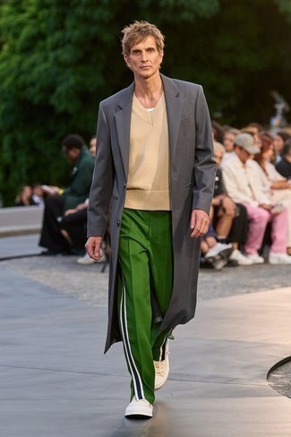 Look alla moda per uomo: Soprabito grigio scuro, Maglione senza maniche beige, Pantaloni sportivi verdi, Sneakers basse di tela beige